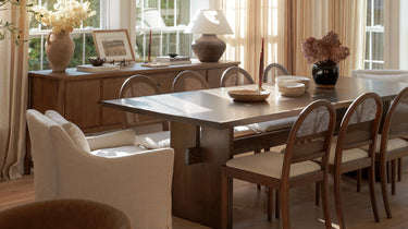 Dining room with a large table and chairs, large windows, and decorative elements.