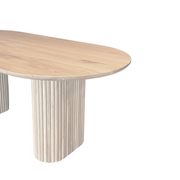 Close-up of the OVALI oval dining table in maple, showing the fine details of the wood grain and the flawless finish.
