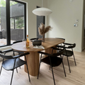 A high-end wooden dining table in a beautiful dining room set up with wine glasses and a casserole.