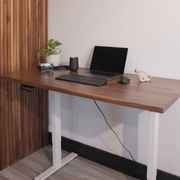 A home office setup featuring a cherry wood standing desk with white legs. This Canadian-made ergonomic desk makes for a productive and stylish workspace.